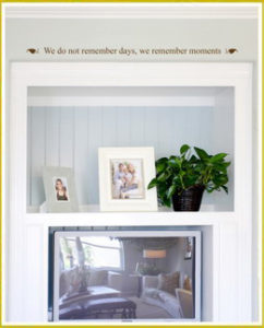 photo wall quote decal above recessed white cabinet with photo