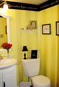 A french wall quote right below the ceiling with water closet and a lavatory in this french-yellow inspired toilet room