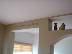An Italian wall decal on the drop beam ceiling with jars above the interior archway