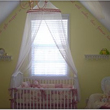 Wall lettering near the ceiling in the baby's room with a crib on the center and a crib canopy curtain