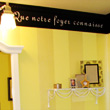 A french wall quotes with toiletries in a yellow french-inspired toilet.