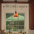 An Italian kitchen wall quote above the kitchen window and in between the kitchen wall cabinets, with kitchen sink and a pendant
