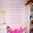 Wall inscriptions in between the open shelves and a dresser in the kids room
