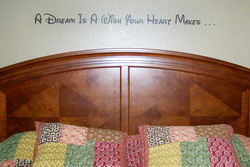 A Dream is a Wish Your Heart Makes - A Disney wall quotation above the bed's headboard with pillows on the bed.