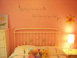 Wall lettering above the bed metal pole headboard with pillows on the bed