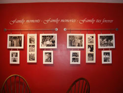 A Family Moments Photo Collage hanging on a red wall with a wall lettering above it.