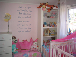 Wall quotes in between the dresser and accessory shelves with a pink baby's crib beside the baby's room window