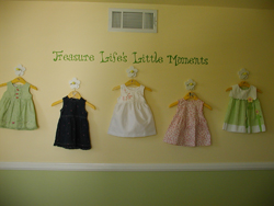 Treasure Life’s Little Moments on a wall hung with five cute little dresses in a Little Girl's Room. Life's Little Moments
