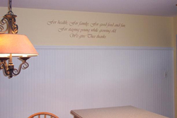 A wall quotation above the table and chair with a chandelier on the left side