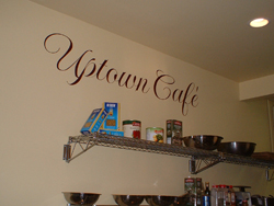 Uptown Cafe wall quote in red colored fonts with accessory shelves.