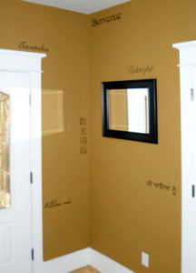 Wall words in different languages in-between the 2 doors and a mirror in black frame